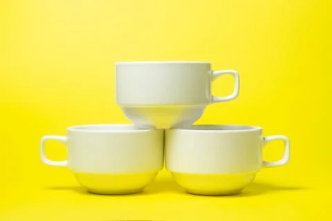 White cups on a yellow background. Stock Photos