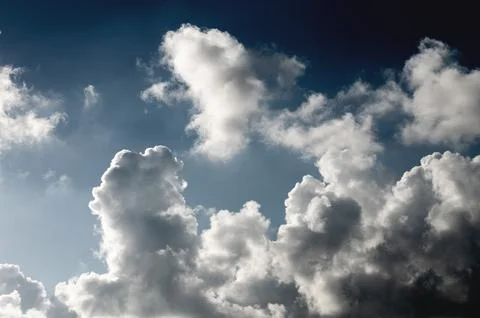 White curly clouds of strange shape in the blue sky on sunny weather. Feeling of Stock Photos