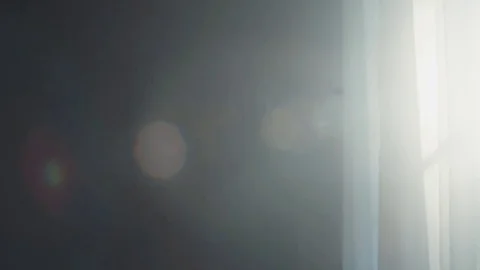 White curtain moving in the deserted dark room. Morning sun lighting the room Stock Footage
