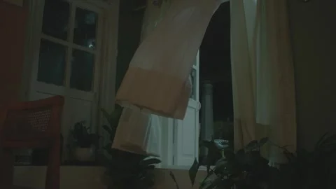 White curtains blowing in the wind at night in a dimly lit room Vídeo Stock 327454883