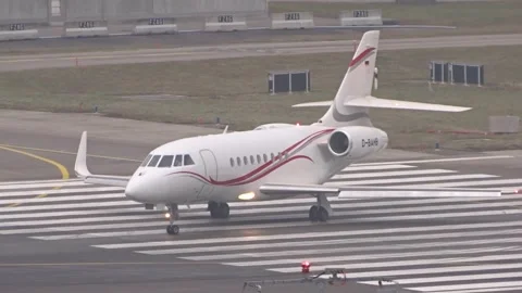 White dassault falcon 2000 private jet red accent stripes rolls zebra striped Stock Footage 328183593