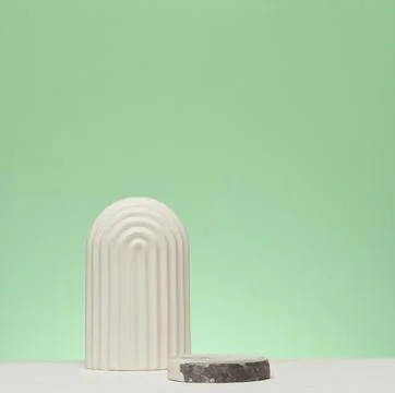 A white decorative element in an arched shape is installed on a green stone.. Stock Photos