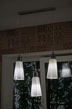 A white decorative lamp hangs from the ceiling. A modern chandelier in the ki Stock Photos