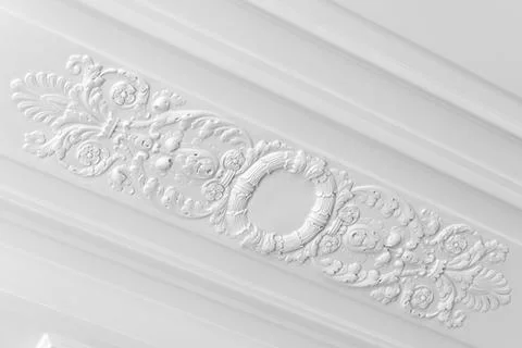 White decorative plaster ceiling molding featuring an ornate circular medalli Stock Photos