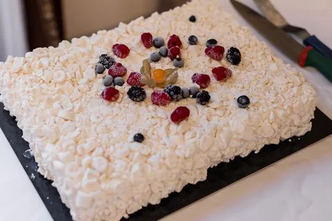 White delicious cake with cream rectangular decorated with berries Foto stock