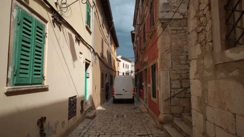 White delivery van carefully navigating a narrow old town alley in Rovinj Stock Footage 342353672