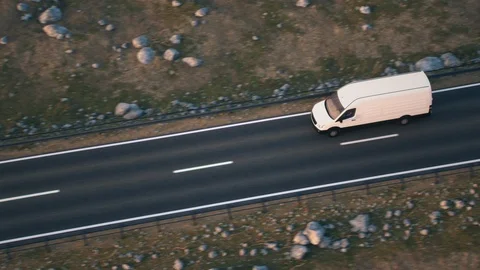White delivery van driving along a desert road into the sunset Stock Footage 104160219