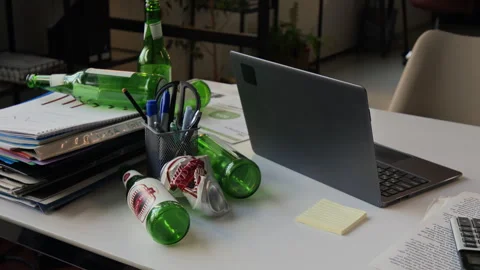 White Desk Featuring Empty Beer Bottles, Pile of Documents, Laptop, Sticky Notes Stock Footage 331529955