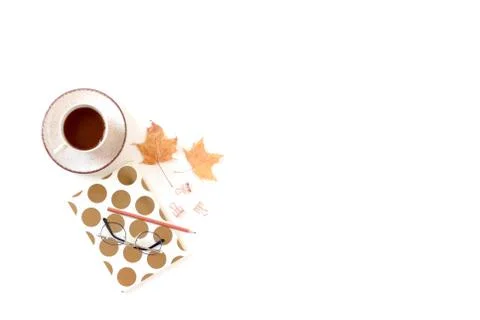 White desk with mug of coffee, notebook, glasses, dried maple leaves. Stock Photos