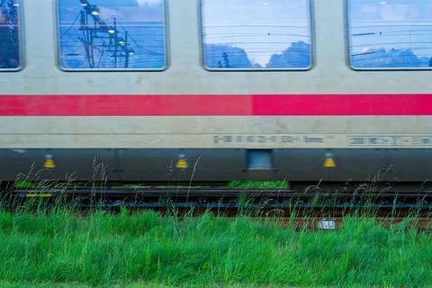 White Deutsche Bahn train with red stripe speeding on tracks Stock Photos