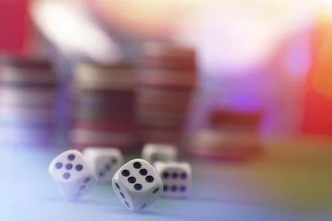 White dice on a green felt table with bokeh background Stock Photos