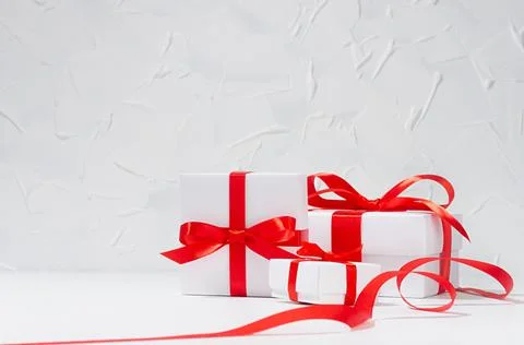 White different size gift boxes with red silk ribbon in white interior, copy  Stock Photos