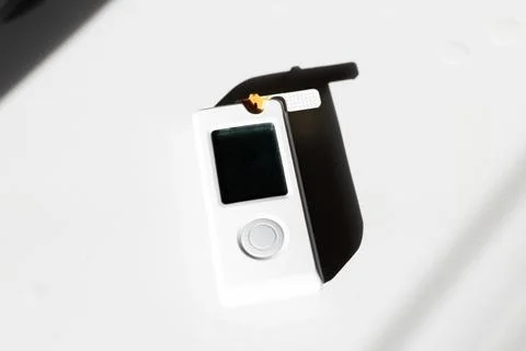 White digital device on textured surface bathed in bright studio light with d 스톡 사진