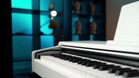 White digital piano in a studio with colored lighting. movement along the keys Stock Footage 156937487