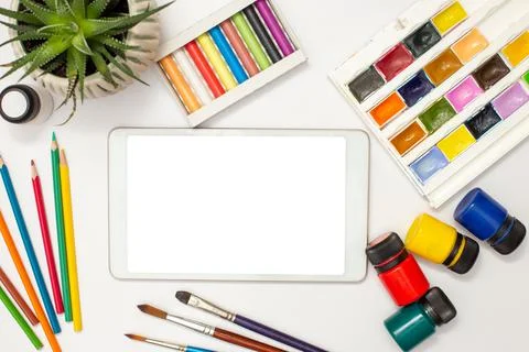 White digital tablet with a blank screen on a white table with multicolor Stock Photos