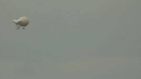 White dirigible on gray sky Stock Footage 89999469