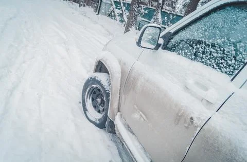 A white dirty SUV covered with a layer of snow. A car for off-road and extreme Stock Photos