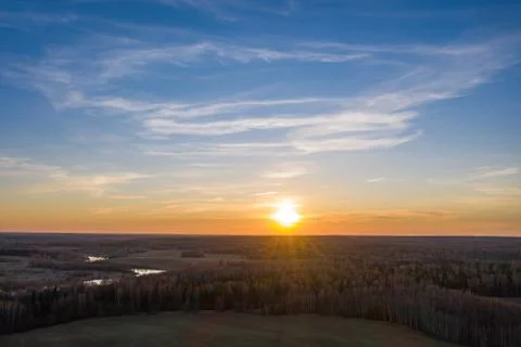 The white disk of the setting sun and the endless fields and forests of Russi Stock Photos