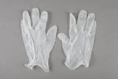 White disposable gloves on a gray background. Stock Photos