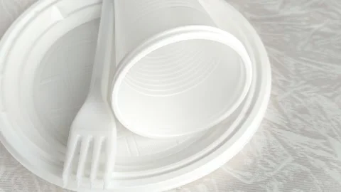 White disposable plastic tableware set on the table. The use of disposable Stock Footage 317669020