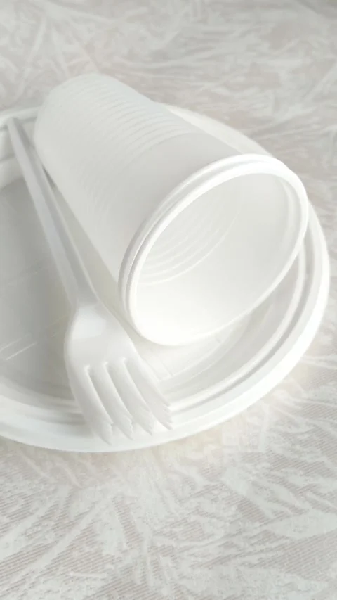 White disposable plastic tableware set on the table. The use of disposable Stock Footage 317669109