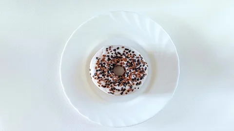 White donut rotating, stop motion, animation on white, from above, flatlay Stock Footage 124647084