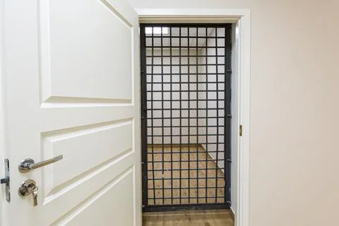 The white door with grid that is as prison cell. Concept of house arrest. Stock Photos
