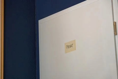 White door with paper note marked private in blue walled room Stock Photos