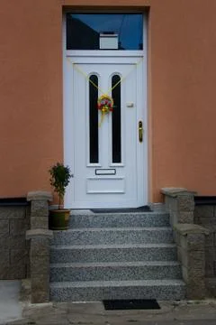 WHITE DOORS OVER STAIRS WITH EASTER DECORATION.Village scene. Stock Photos