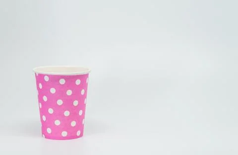 White dot pattern on Pink paper cup with white background and selective focus Stock Photos