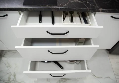 White drawers in a custom built-in kitchen. Modern fittings and furniture in the Фото