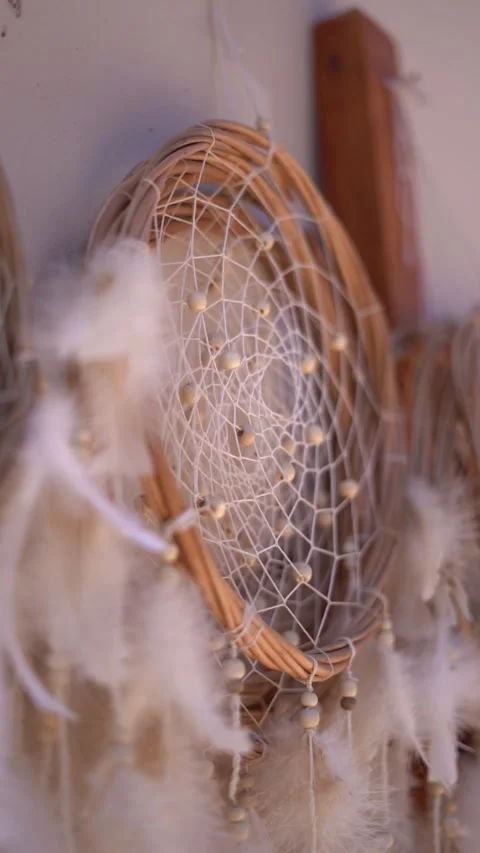 A white dreamcatcher with feathers hanging from it Stock Footage 329724963