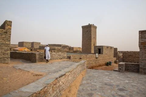 White dressed Beduin in front of historic bricked mosque at world hertiage si Stock Photos
