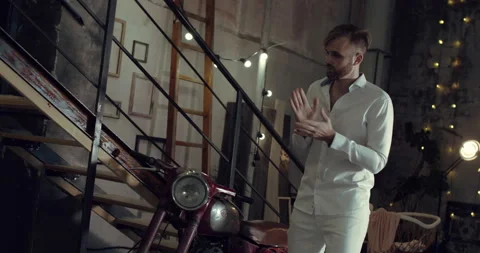 A white dressed man is dancing in his garage Stock Footage 135113234