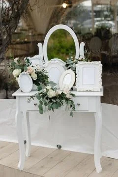 White dressing table decorated with flowers and empty photo frames for wedd.. 스톡 사진