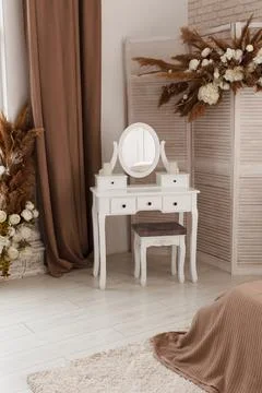 White dressing table with oval mirror and chair is part of cosy interior of.. Foto stock