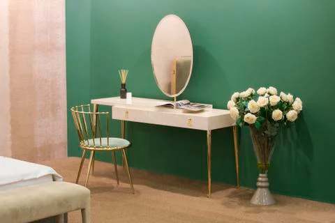 White dressing table with wicker elements, a room with a green wall and golde Stock Photos