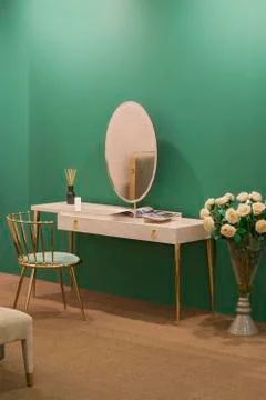 White dressing table with wicker elements, a room with a green wall and golde Stock Photos