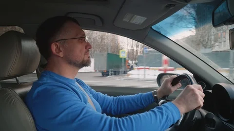 White driver drives car passing by construction in city. Sunset in city Stock Footage 109327381