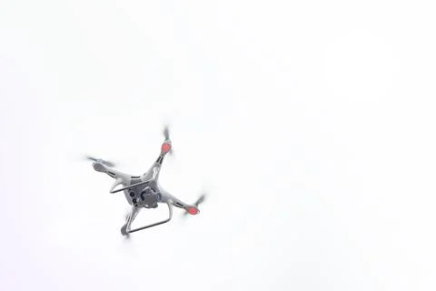 White Drone with Camera Flying in Blue Sky. UAV Concept Стоковые фото