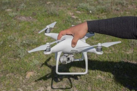 White drone with digital camera flying in sky over mountain Drone with high r Stock Photos