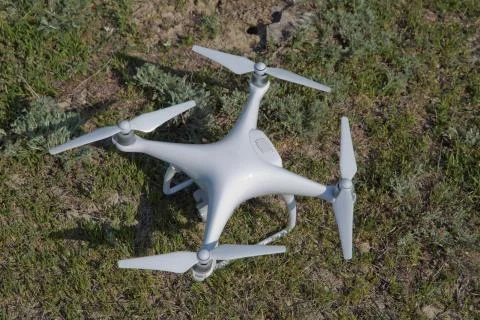 White drone with digital camera flying in sky over mountain Drone with high r Stock Photos
