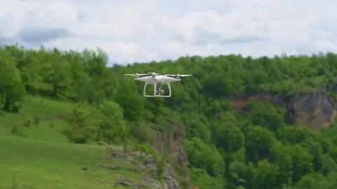 A white drone flies over the mountains and shoots a video. Stock Footage 157782436