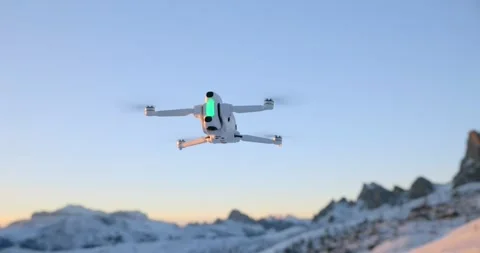 White Drone Fluing Above Snowy Mountains at Sunset Stock Footage 343930731