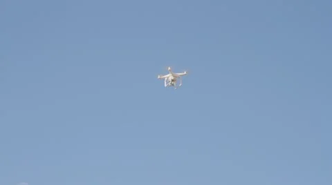White drone hovering in a bright blue sky Stock Footage 62979371