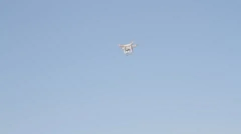 White drone hovering in a bright blue sky Video stock 62979846