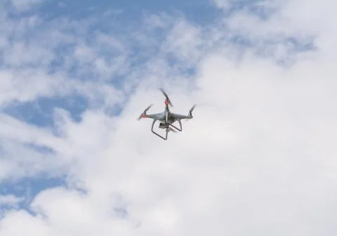 White drone hovering in a bright blue sky Foto stock