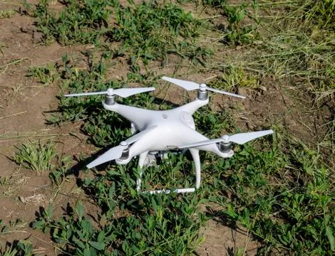 White drone on the soil with grass. Stock Photos