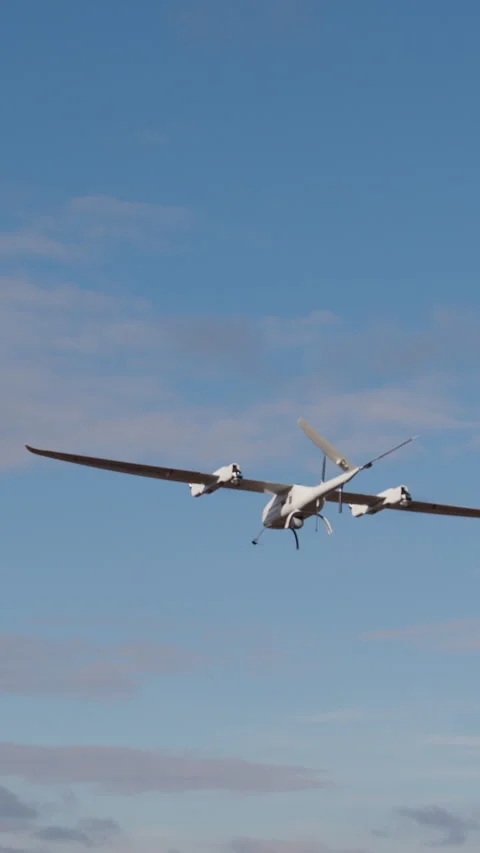White drone takes off from the ground at high altitude over open fields. Drone Stock Footage 314307967