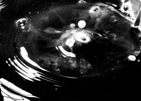 A white drop in the black water Stock Photos